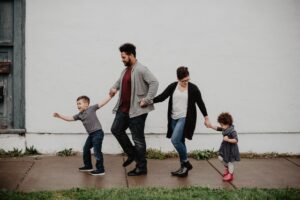 A family walking hand in hand on a sidewalk